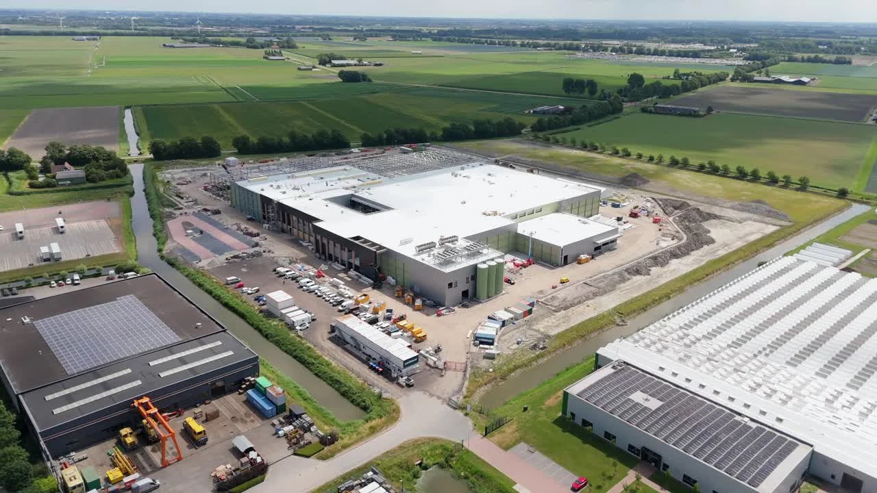 Uitgestrekt gebouw in aanbouw tussen de velden, luchtfoto